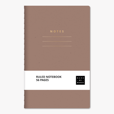 Pocket-sized notebook with ruled pages featuring an almond cover with gold foil accents – front view with informative paper wrap.