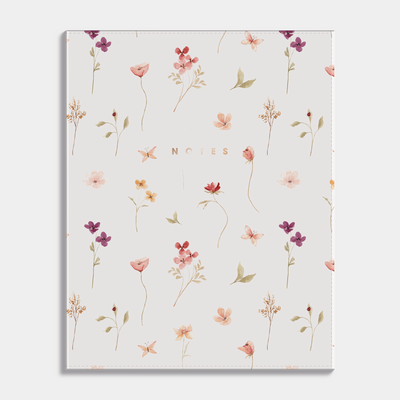 Notebook with a flexible cover and a design of delicate flowers on a light background. Frontal view.